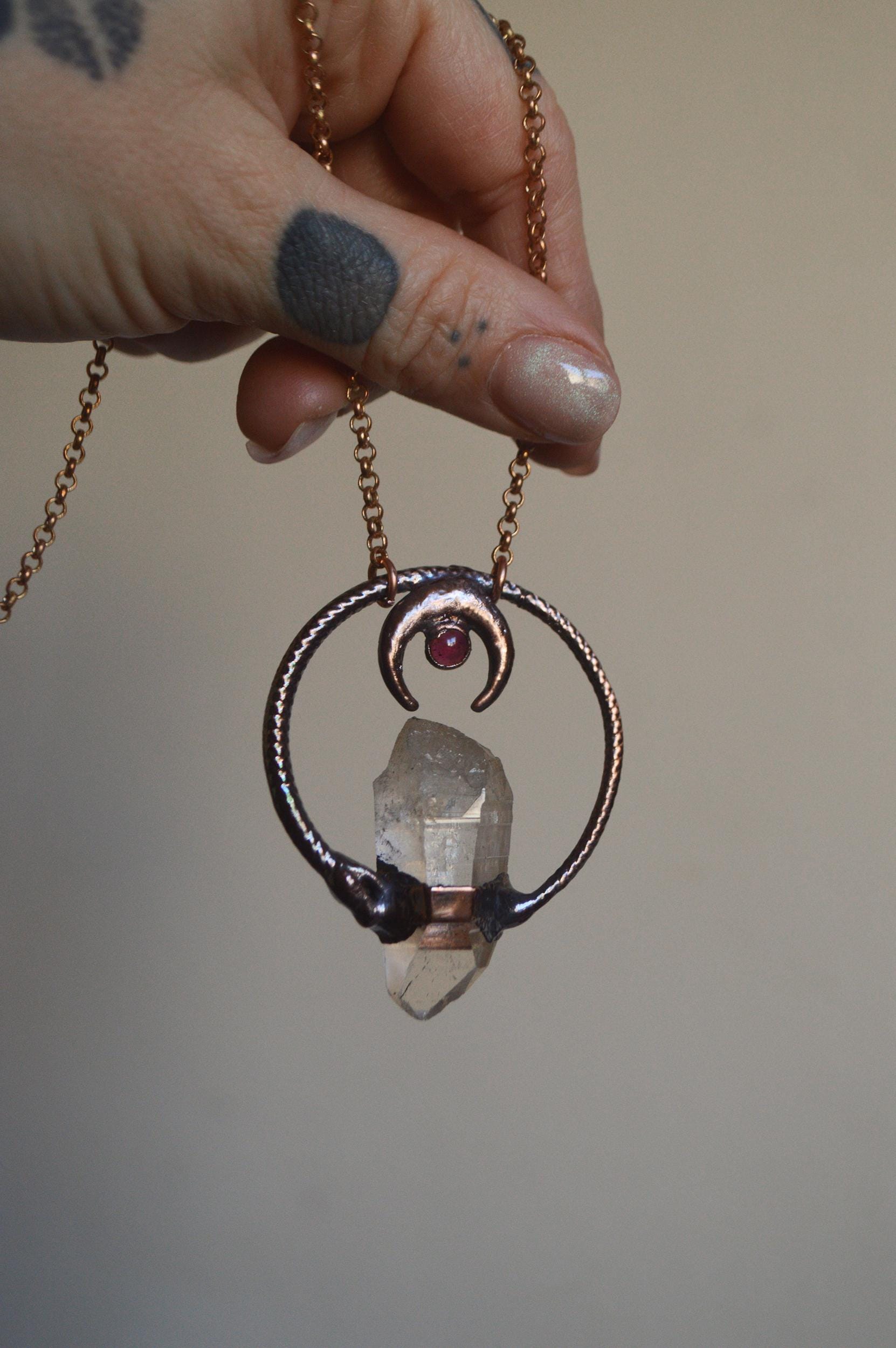 Ouroboros garnet and quartz point pendant necklace