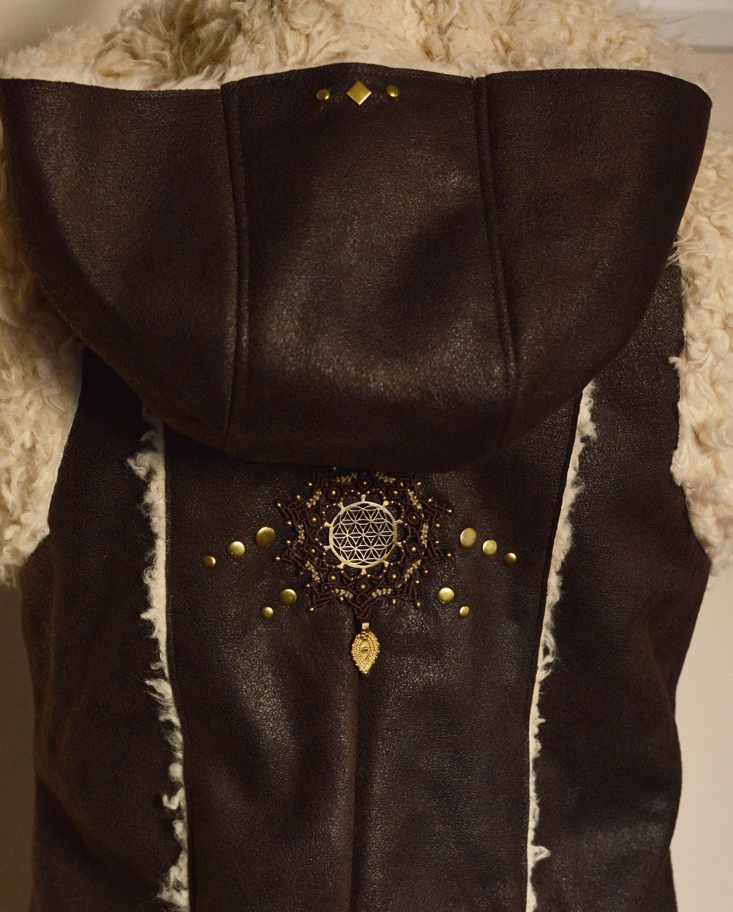 Dark brown faux fur waistcoat with large hood. Flower of life macramé applique. Sacred geometry festival clothing