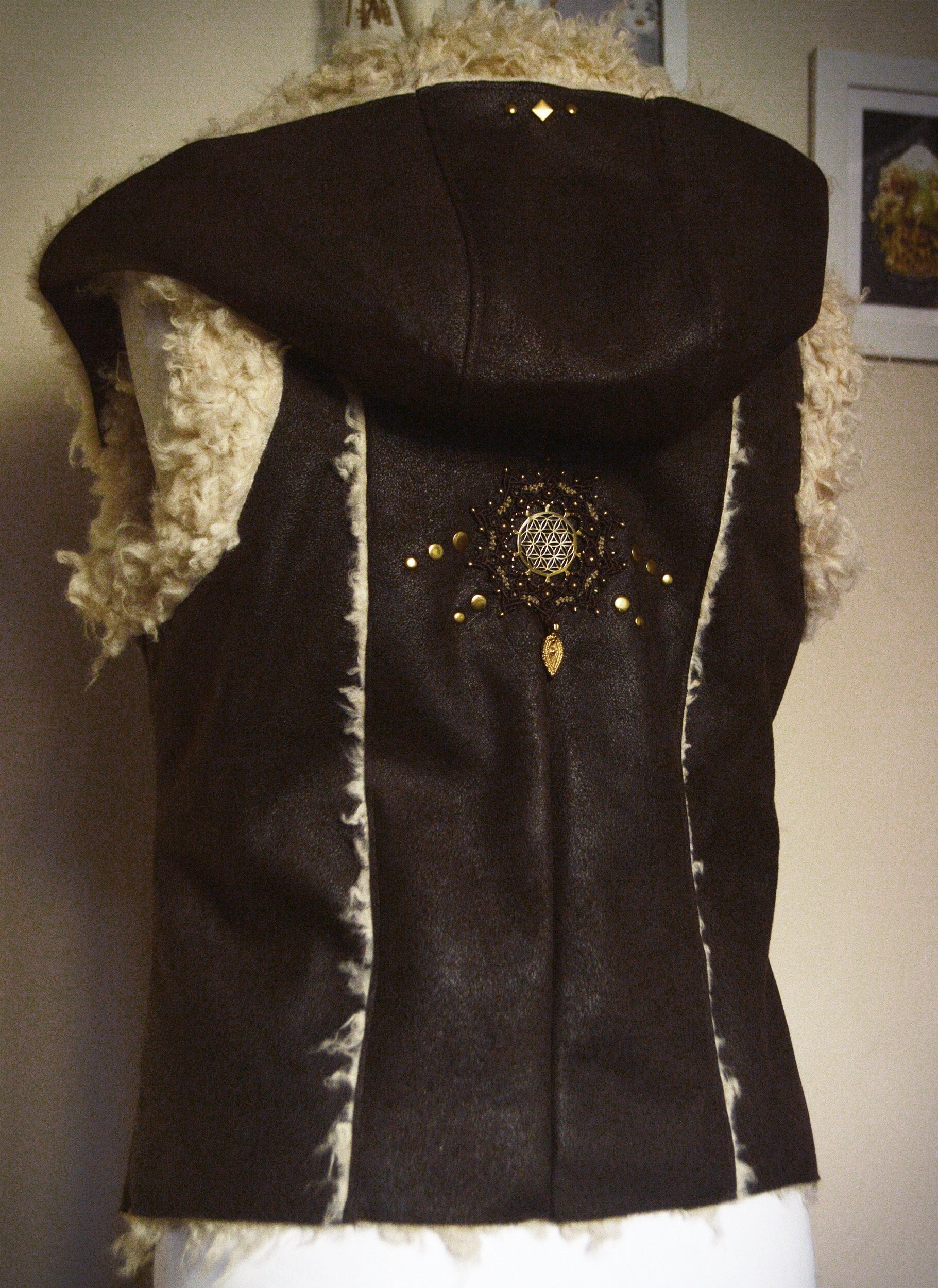 Dark brown faux fur waistcoat with large hood. Flower of life macramé applique. Sacred geometry festival clothing