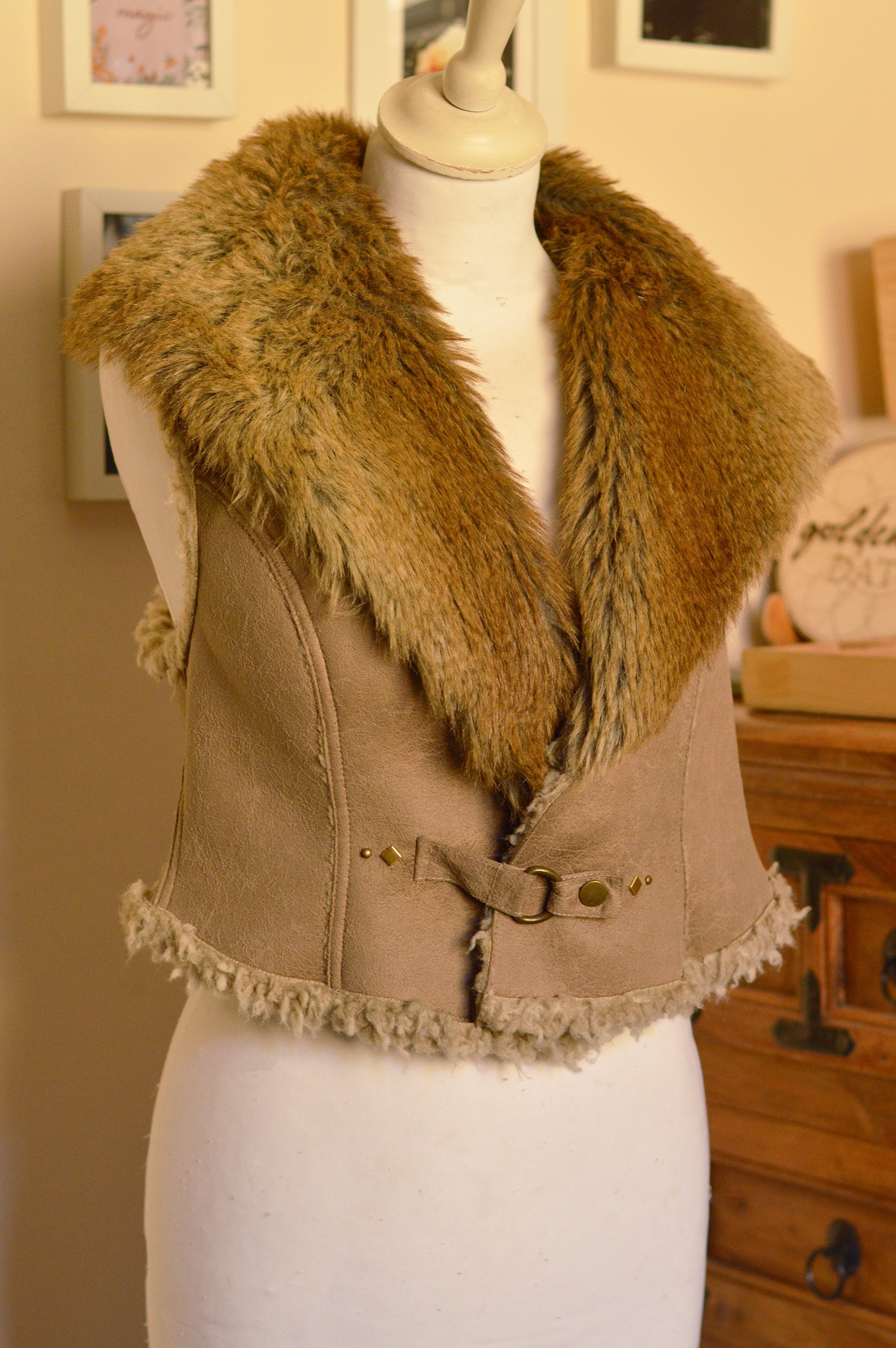 Large faux fur collar, taupe cropped waistcoat. Dream catcher embellished brown jacket